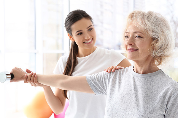 physical therapist with a resident in the rehab gym