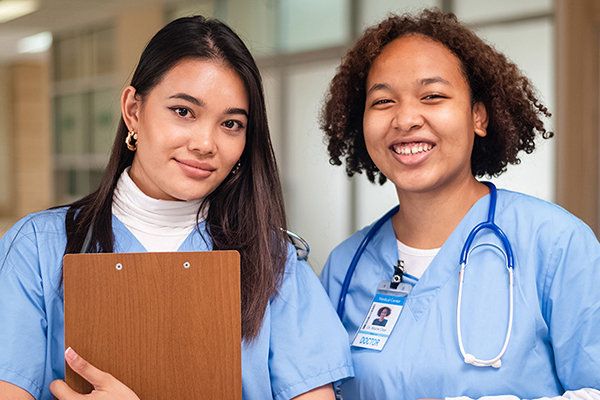 Smiling nurses wearing blue scrubs